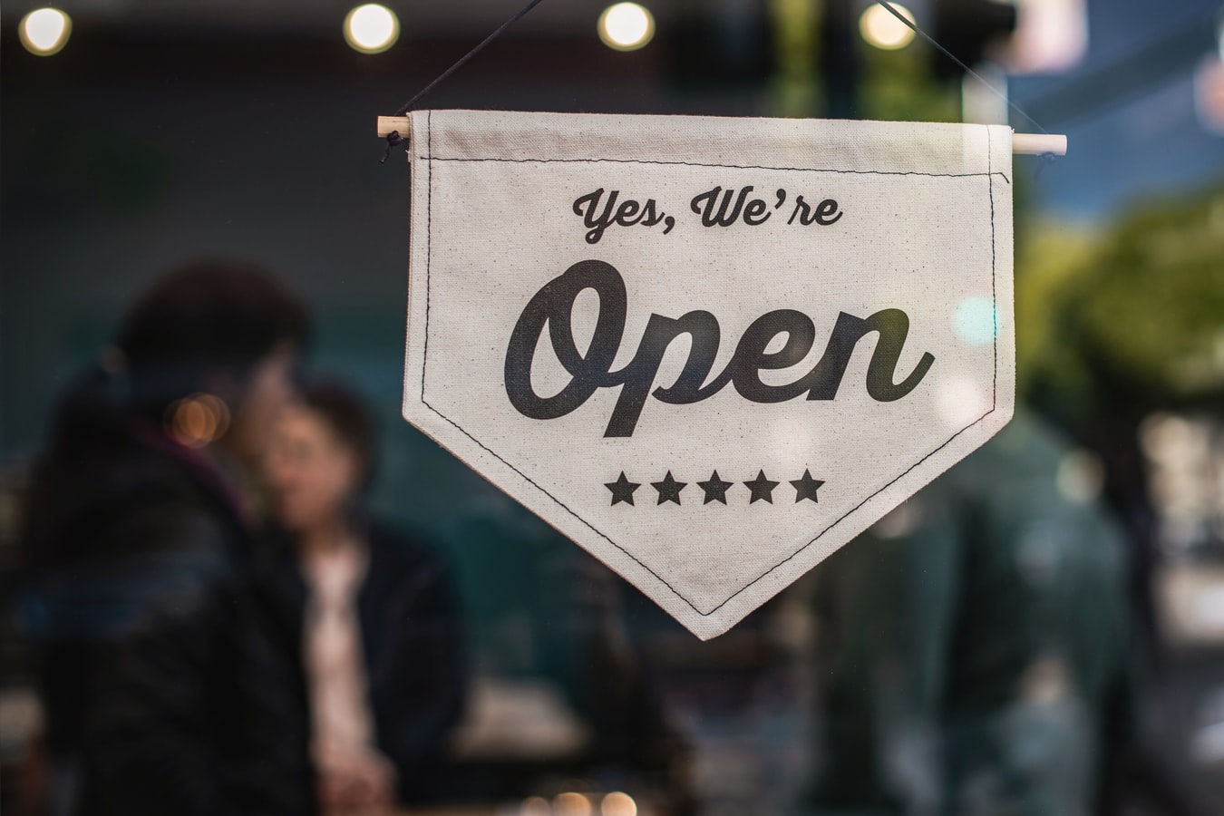 Open sign hanging on door of busniess shop